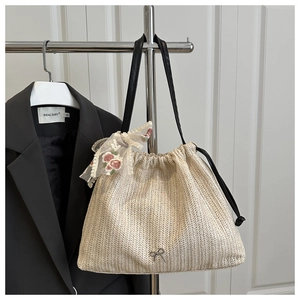 Detail of woven straw bucket bag with lace bow, red rose embroidery and drawstring