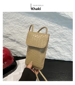 Detail van de kaki geweven textuur en de slanke schouderband van de crossbody telefoontas
