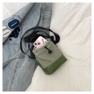 Detail of green nylon crossbody phone bag showing interior space for a mobile phone