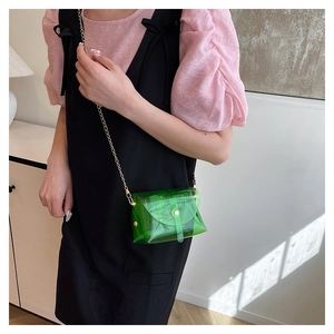 On-body view of green transparent jelly crossbody bag with gold chain strap