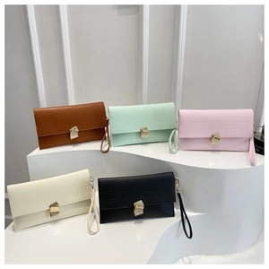 Macro shot of stylish textured clutches in five colors with unique gold metal buckles
