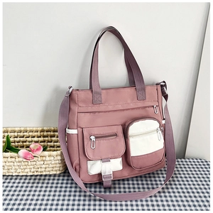 Close-up of pink canvas tote bag with multi-pocket design on a plaid tablecloth