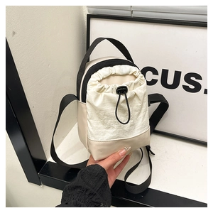 Detail of waterproof canvas patchwork crossbody bag with drawstring closure and strap