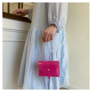 Detail showing bright rose pink jelly envelope bag with gold chain and snap button closure