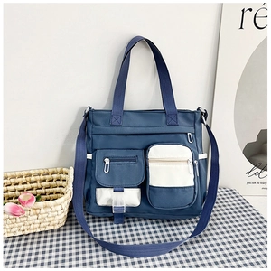 Detail of blue and white canvas tote bag with large double front pockets and buckles