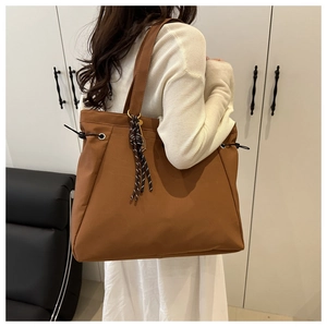 Detailed back view of a brown tote bag with drawstring side and woven strap detail