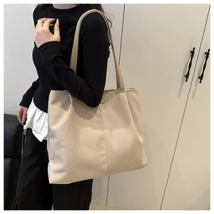 Sac fourre-tout beige en nylon porté par un mannequin soulignant sa grande taille pratique