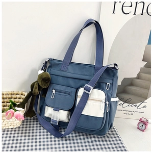 Dettaglio della borsa tote in nylon blu con multitasche e ciondolo a forma di rana
