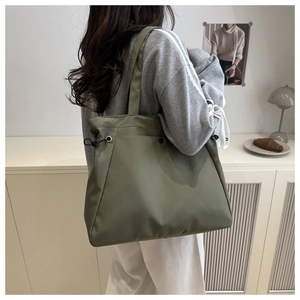 Detail view of large olive green tote bag with side drawstring and metallic eyelets