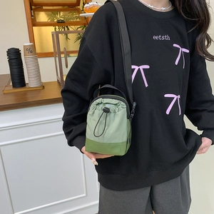 Green drawstring crossbody phone bag with adjustable nylon strap for casual use