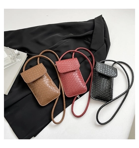 Detail van geweven mini-telefoontassen in bruin, bordeaux en zwart kunstleer materiaal
