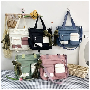 Detailed display of large canvas bags in five colors with functional front pockets and plush toy