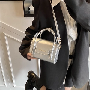 Chic silver square handbag with adjustable strap shown styled with a modern outfit