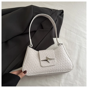 Detail of white woven textured underarm bag featuring a silver star buckle and PU leather