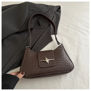 Detail of dark brown woven texture shoulder bag featuring a silver star buckle ornament