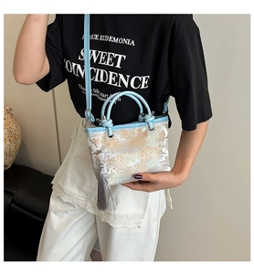 Detail of light blue jacquard bucket bag with Chinese landscape embroidery and grey tassel