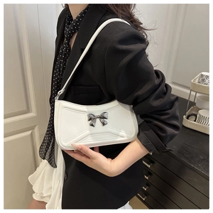Detail of white PU leather underarm bag with silver bow and geometric pattern