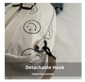 Detail of detachable hook and smiley face print on beige corduroy backpack