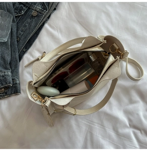 Vue de dessus de l'intérieur du sac seau en cuir beige montrant sa grande capacité