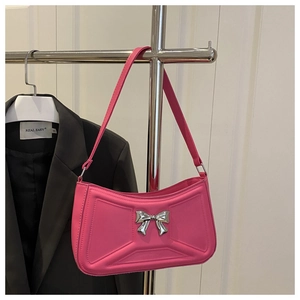 Detail of pink faux leather bag with silver metal bow and geometric embossed pattern