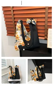 Detail of floral bow and pearl decoration on a large capacity shoulder tote bag