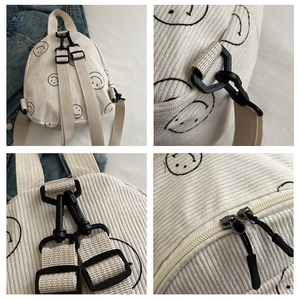 Detailed close-up of corduroy backpack featuring smiley print and durable black plastic buckles