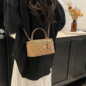 Brown quilted leather square box bag with gold chain strap worn cross-body by a model