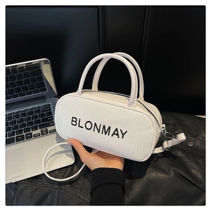 Detail showing white cylindrical baguette bag with woven texture and black branding