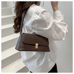 Détail du sac à bandoulière tressé marron foncé avec fermoir métallique doré élégant