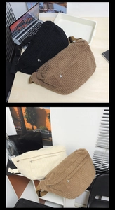 Detail of corduroy crossbody bag with wide nylon strap and metal zipper in office setting