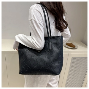 Close-up of elegant floral embossed texture on a black large capacity tote bag
