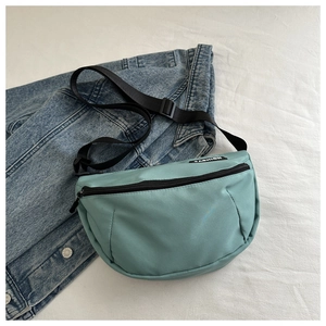 Détail du sac croissant vert menthe avec étiquette mode et sangle réglable
