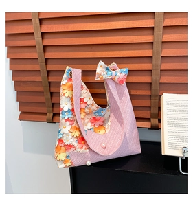 Detailed view of floral tote bag featuring 3D flower accents and pink woven texture