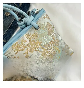 Detailed embroidery of classical Chinese landscapes on luxury satin bucket bag with silk tassels