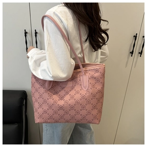 Detail shot of pink floral tote bag featuring dense cherry blossom patterns and brand logo
