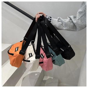 Gros plan de cinq sacs bananes en nylon colorés en orange rose et noir avec étiquettes