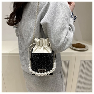 Detail of snake embossed leather mini bag with large pearl handle and gold chain strap