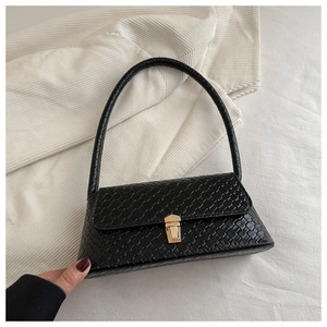Gros plan du sac noir à texture tissée avec un fermoir métallique doré élégant