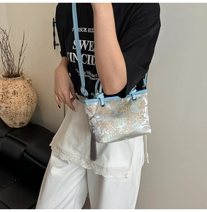 Detailed embroidery of classical garden scenery on a silver brocade bucket bag