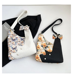 Detail of floral tote bags with 3D flowers, pearls, and bow shoulder straps in black and white