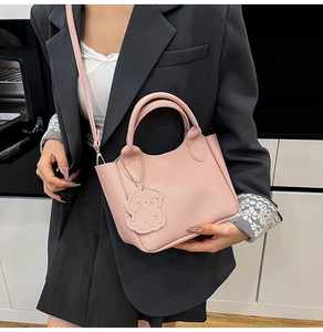 Détail du sac seau en cuir grainé rose avec un charmant pendentif en forme de chien