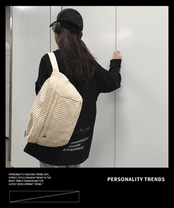 Detail of off-white corduroy crossbody bag with adjustable metal buckle on model