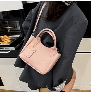 Sac seau en cuir grainé rose avec pendentif chien et détails en métal doré