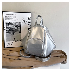 Detail of silver geometric backpack with metallic finish on textured fabric surface