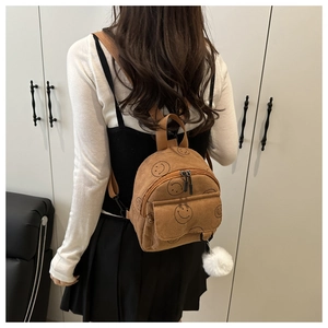 Brown corduroy smiley backpack showing back-view model fit and compact size details