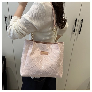 Detail of pink floral embroidered tote bag with golden chain straps for daily commute