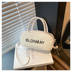 Close-up of white woven Boston baguette bag with black letters and dual handles