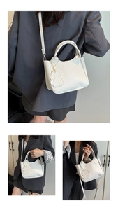 Vues détaillées du sac seau blanc à motif litchi avec pendentif chien et sangle