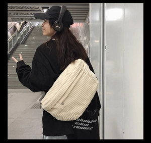 Side view of large corduroy crossbody bag in cream white showing striped texture