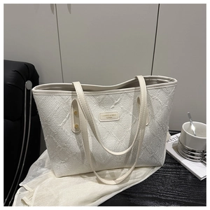 Detail of white tote bag with textured knit pattern and branded logo metal plate